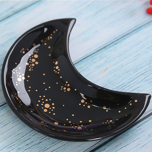 black dish shaped like a half moon with gold foil accents trinket dish