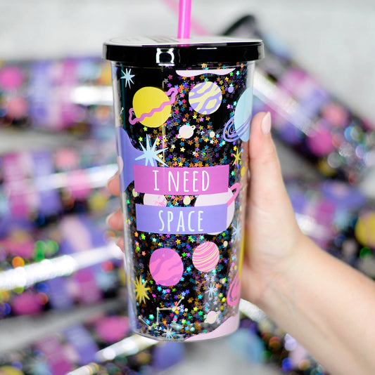 black double wall acrylic tumbler with glitter. Print includes planets stars and the words I need space. Tumbler includes hot pink reusable drinking straw